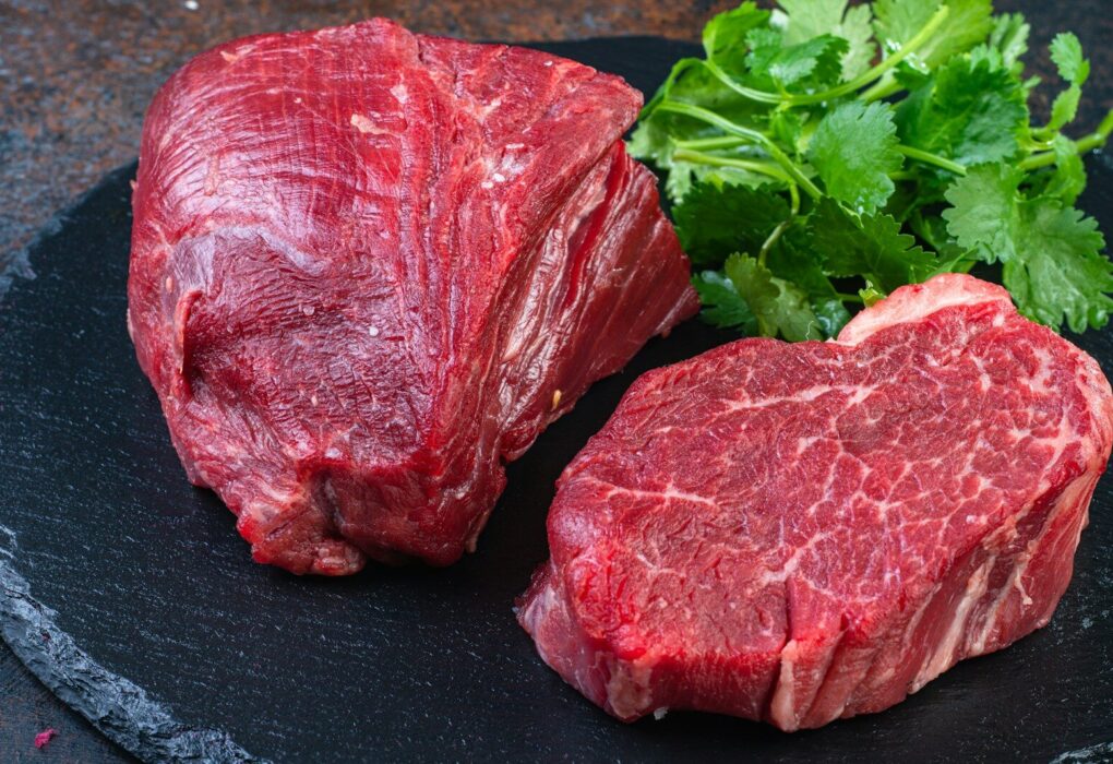 Two steaks on a plate with parsley