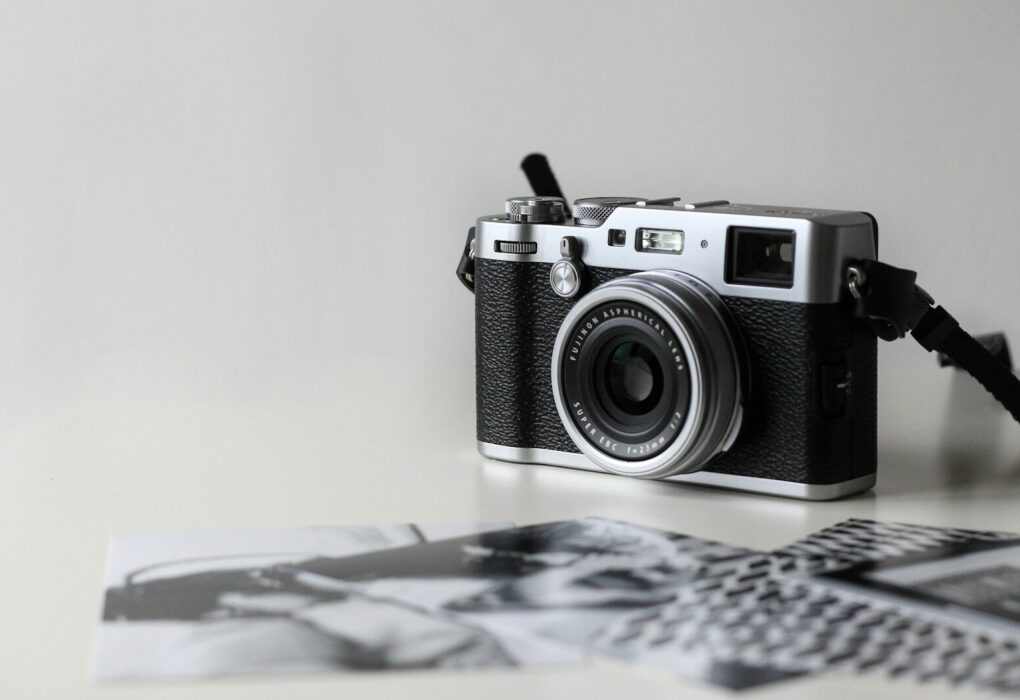 black and gray film camera near printed photos
