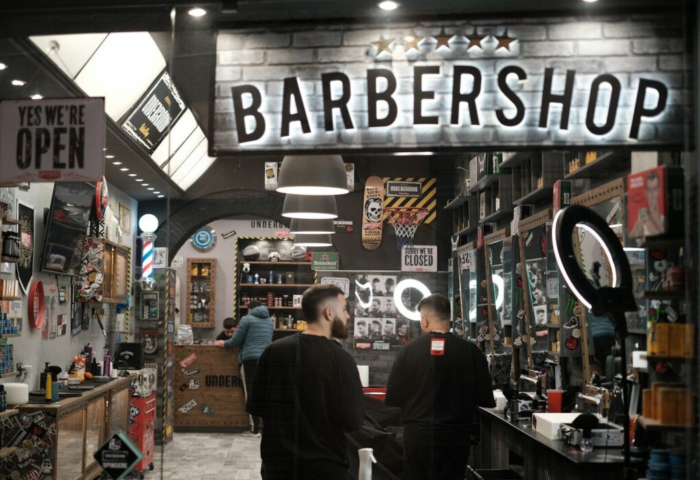 a barber shop with two men standing in front of it